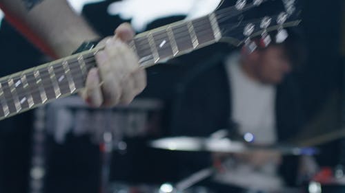 A Close Up of a Person Playing an Electric Guitar