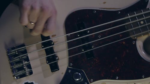 A Close Up of a Hand Playing a Bass Guitar