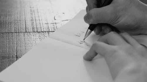 Close Up of a Person Writing on a Paper
