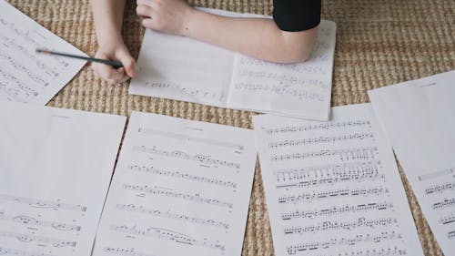 A Little Girl Writing on a Music Notebook