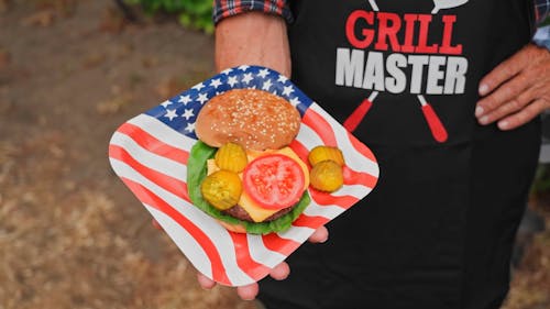 A Person Holding a Plate with Burger