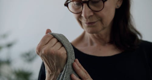 A Medium Close Up of a Woman Caressing and Smelling a Jacket