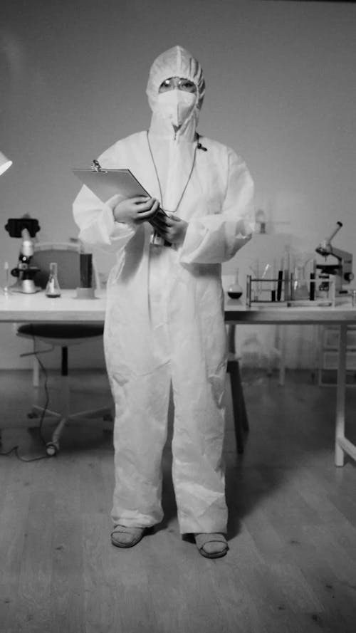 A Person Holding a Clipboard while Posing in a PPE Suit