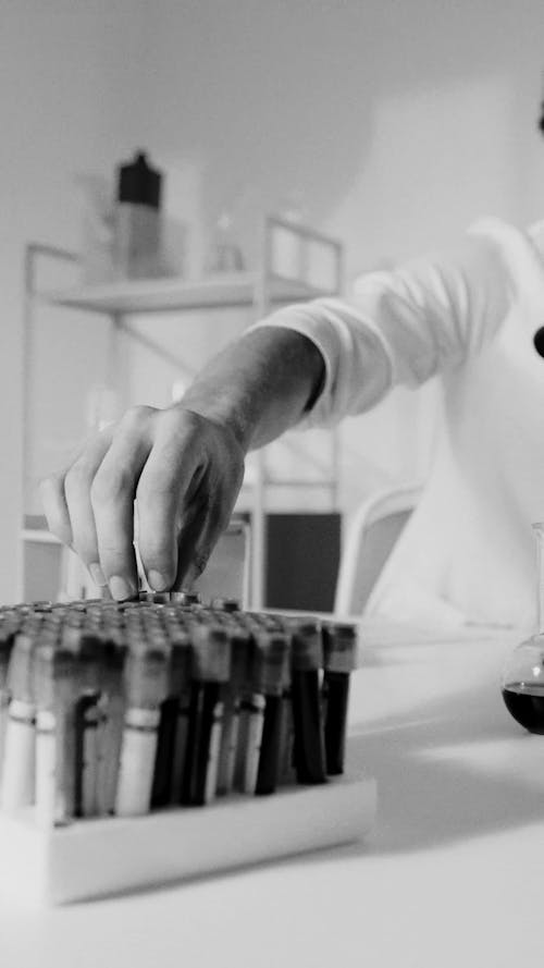 A Male Scientist Looking at a Vial