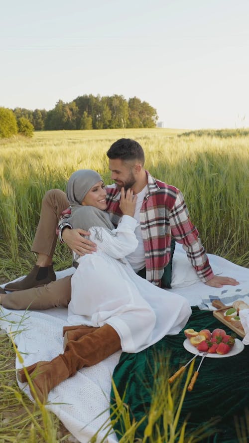 A Man and a Woman Holding and Looking at each other at a Picnic Date