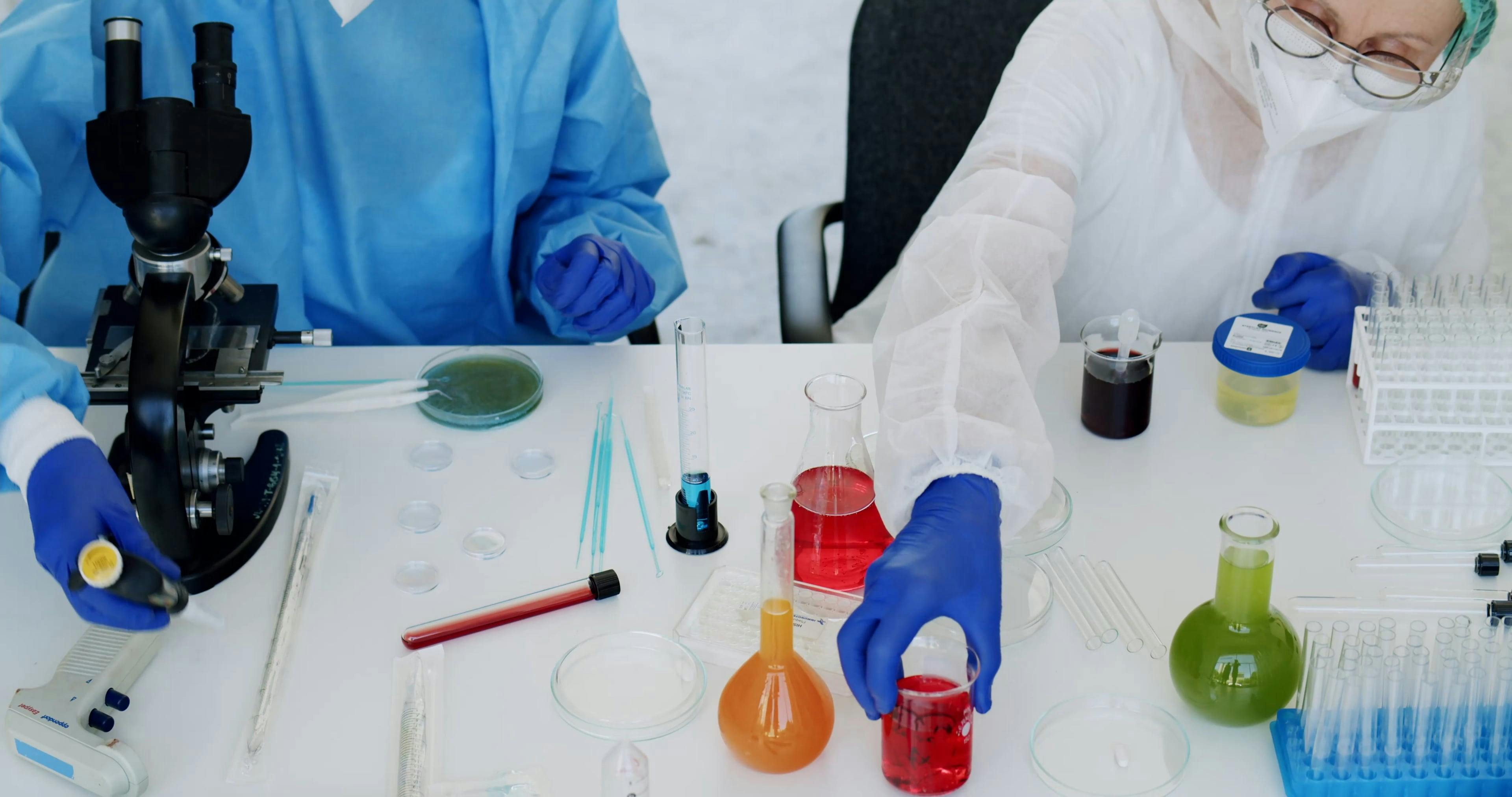 Chemists Organizing Chemistry Lab Equipment on a Table · Free Stock Video