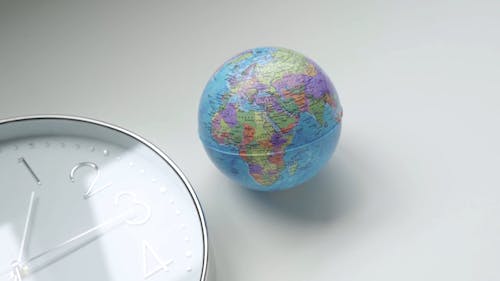 Clock and Globe on a White Background