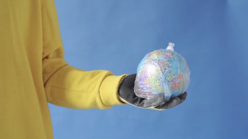  A Man Holding Globe Inside a Plastic Bag
