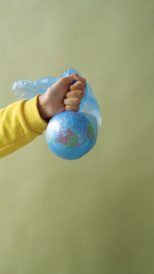 A Person Holding a Globe in the Plastic Bag