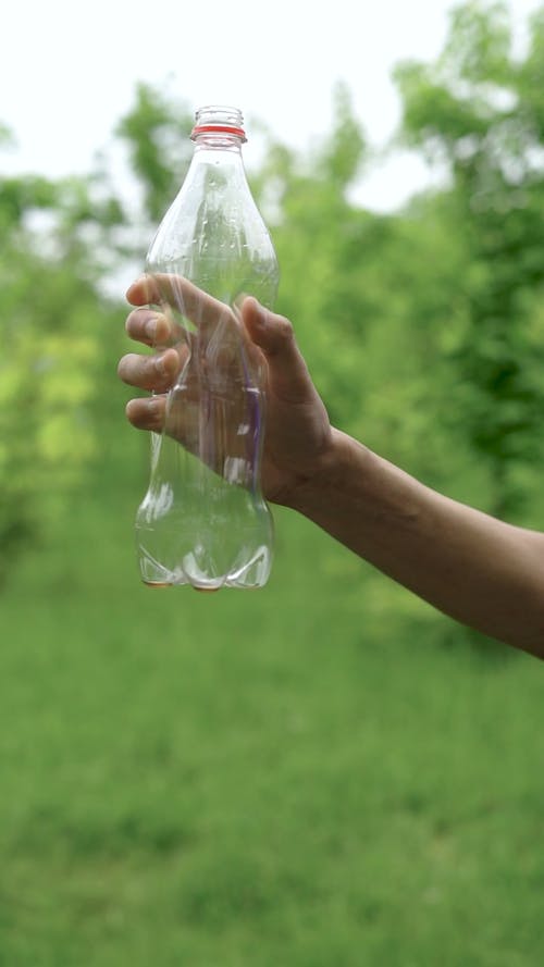 Close up of a Hand Crushing a Plastic Bottle