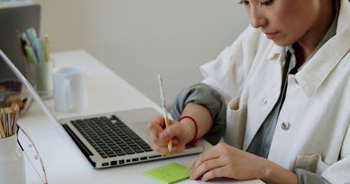 A Person Writing on a Sticky Note