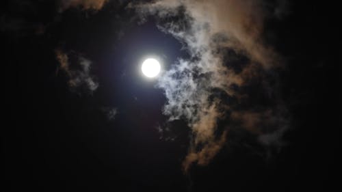 Beautiful Moon Rises through Night Clouds