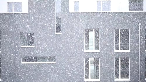 Snowfall In Front Of A Building