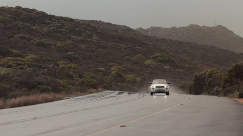 An SUV Driving on the Road on a Rainy Day