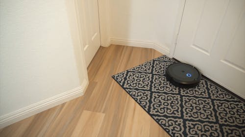 A Robotic Vacuum Cleaner Sweeping the Rug