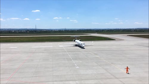 Man Assisting An Airplane In Runway