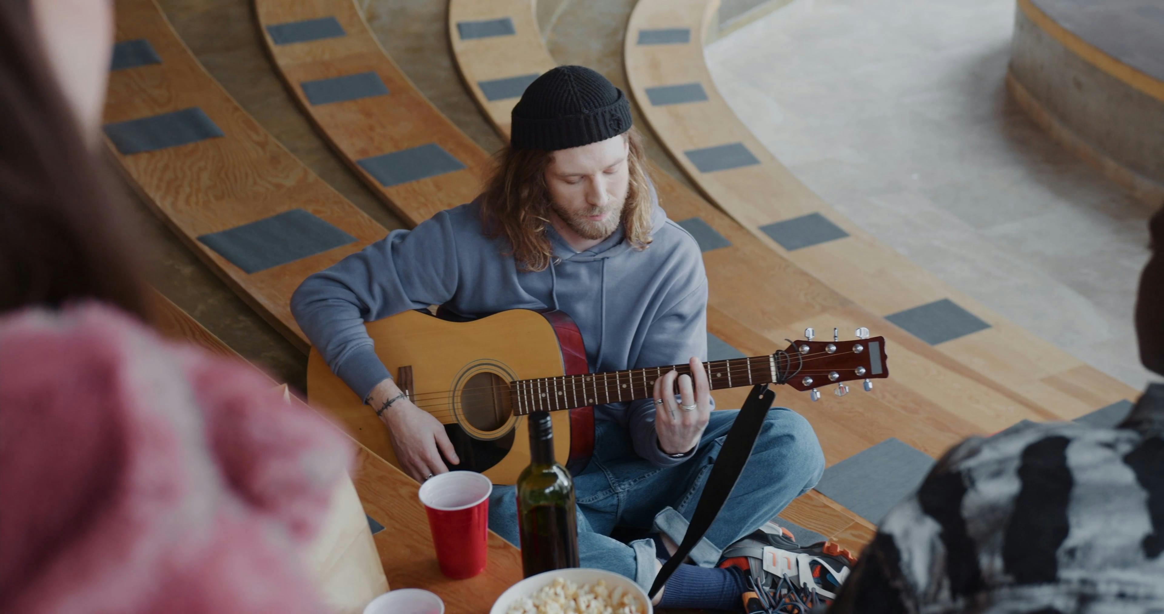 Man Sitting on Bleacher Playing Guitar Free Stock Video Footage