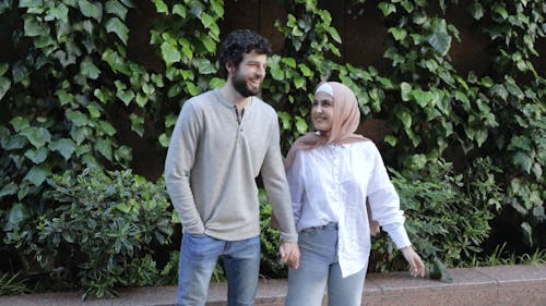 Couple Looking at Each Other While Holding Hands