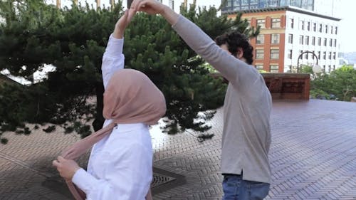 Woman Wearing Hijab Dancing with a Man