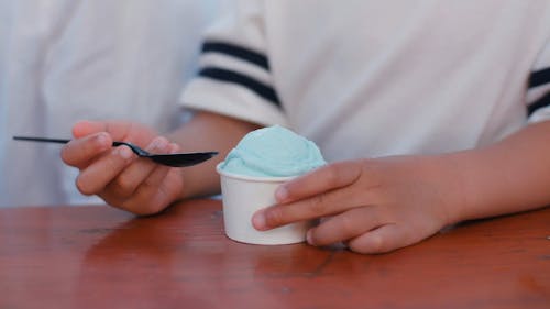 Close-Up View of a Person Eating Ice Cream in a Paper Bowl