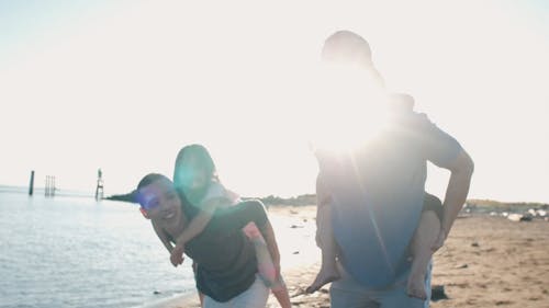 Dads Having Fun Carrying Their Children at the Beach