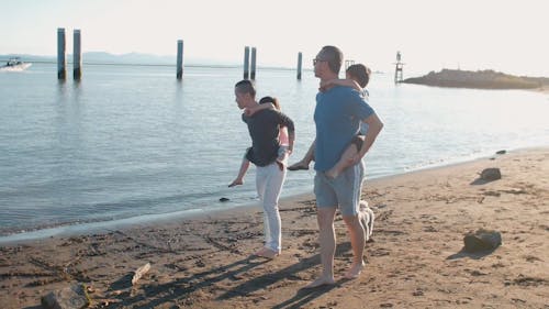 Dads Having Fun Carrying Their Children at the Beach