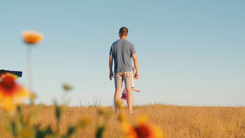 A Man Watching Kids Playing with a Kite