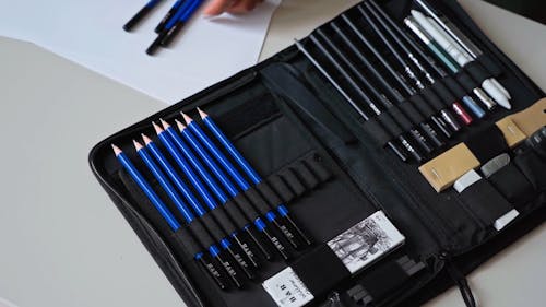 A Person Organizing Pencil in a Pencil Case