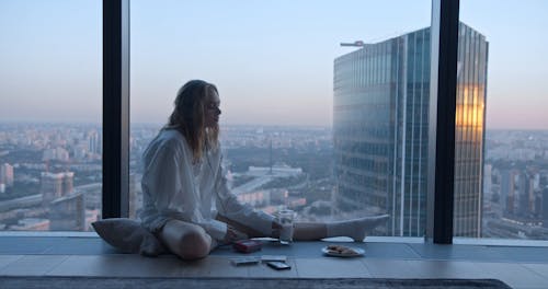 A Woman Drinking a Glass of Milk While Listening to Music