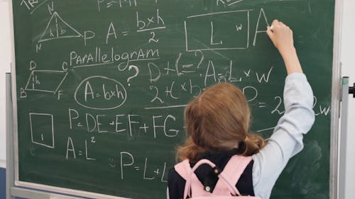 Girl Writing on a Blackboard with a Chalk