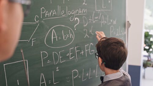 Student Answering a Math Problem on the Blackboard