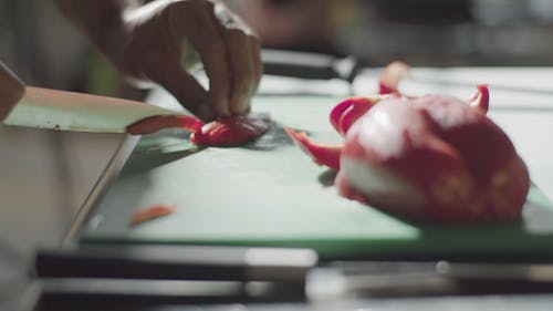 A Person Slicing a Red Bell Pepper