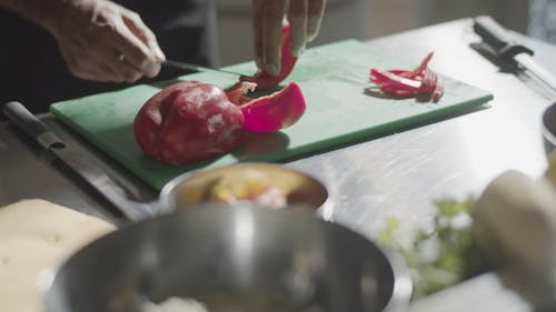 A Person Slicing a Red Bell Pepper