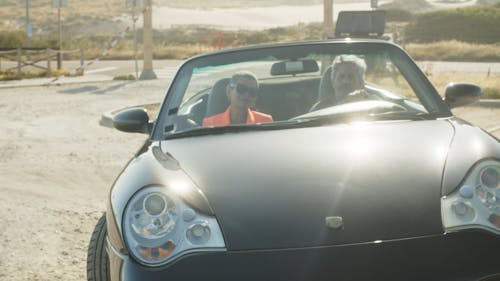 A Couple Riding on a Cabriolet Car