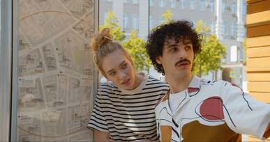 a man and a woman talking beside a map of a city