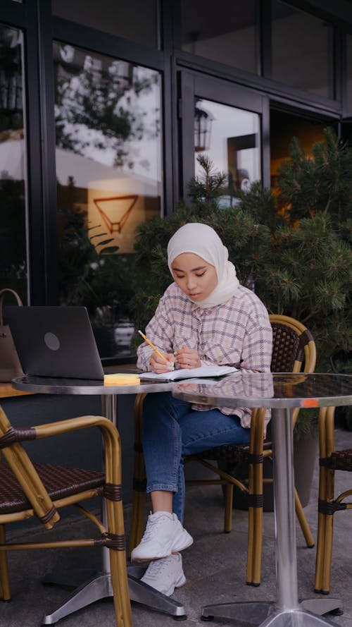 A Woman Remote Working at a Café