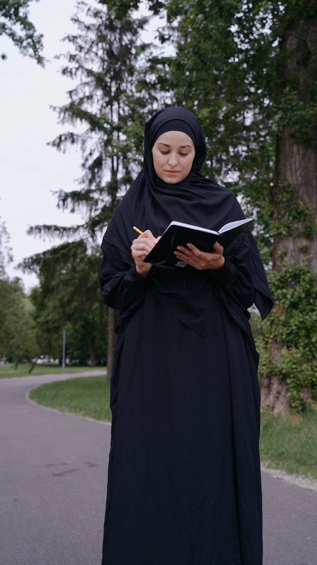 A Woman in a Hijab Writing on a Notebook Free Stock Video Footage ...