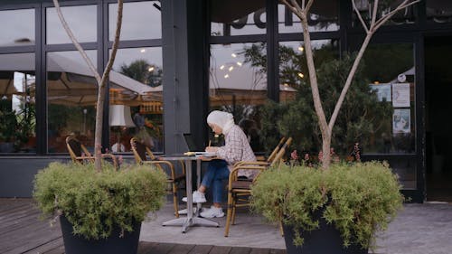 Woman Putting Sticky Note on a Laptop