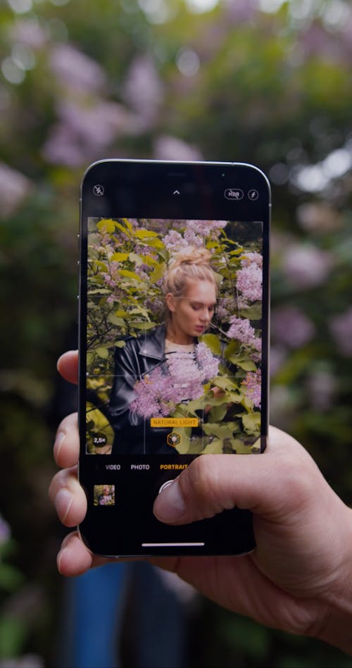 Close up of a Person Taking Photos of a Woman on a Cellphone