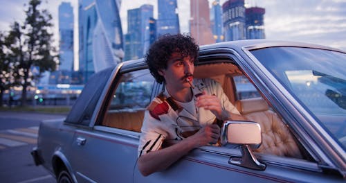 Man Lighting a Cigarette While Inside a Vintage Car