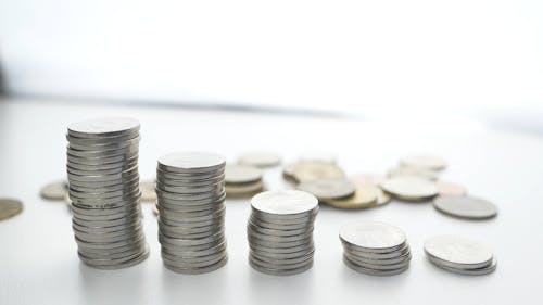 Person Placing Coin On Stacks Of Ten Romanian Bani Coins