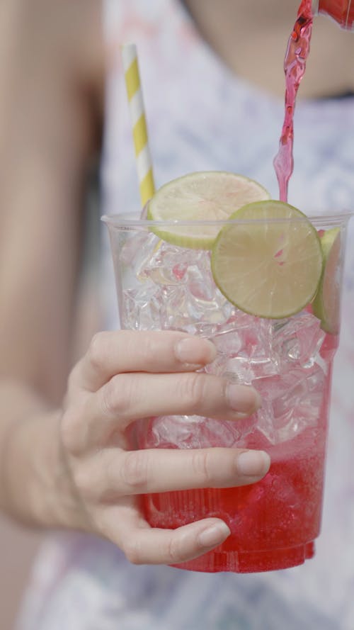 Close up of Soda Being Poured in an Ice Filled Plastic Cup