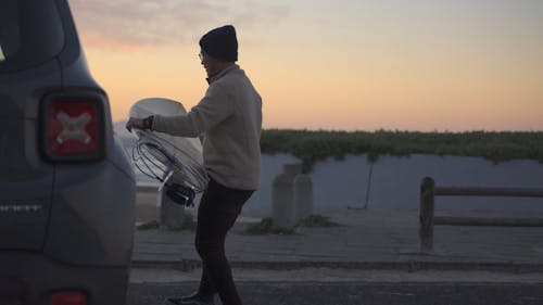 A Man Taking his Surf Equipment out of the Car