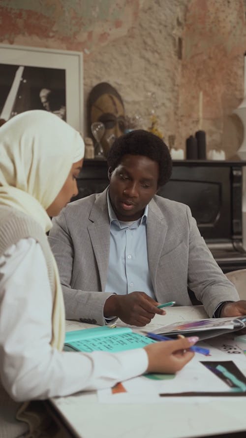 A Man Discussing with a Coworker while Looking at a Document