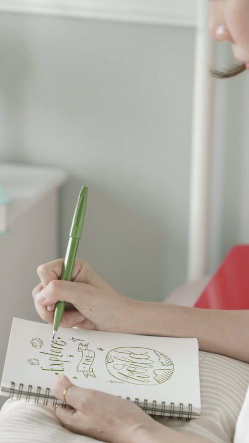 Person Writing on a Notebook