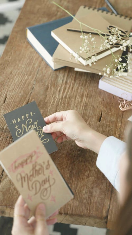 A Person Placing Various Greeting Cards on a Table