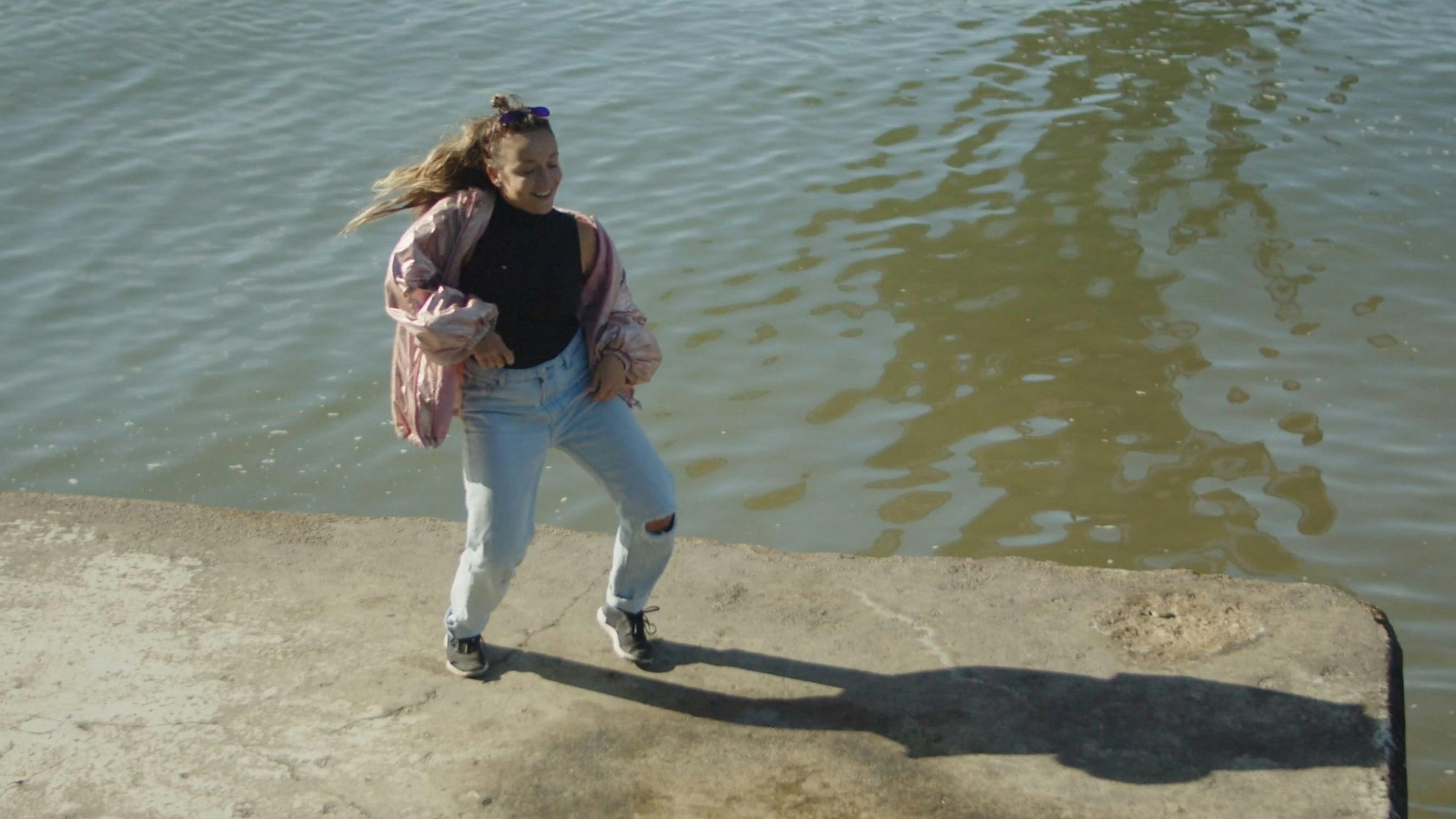 Woman Dancing On Concrete Surface Near A River Free Stock Video Footage
