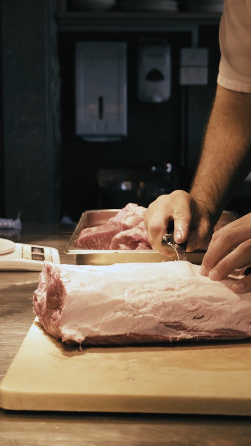 Person Slicing a Meat
