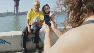 a couple sitting while posing under the bridge