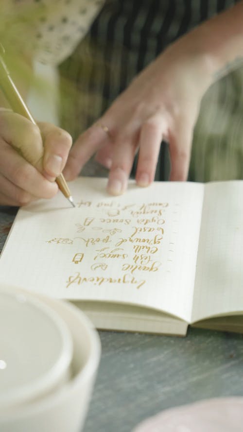 Person Writing On a Notebook